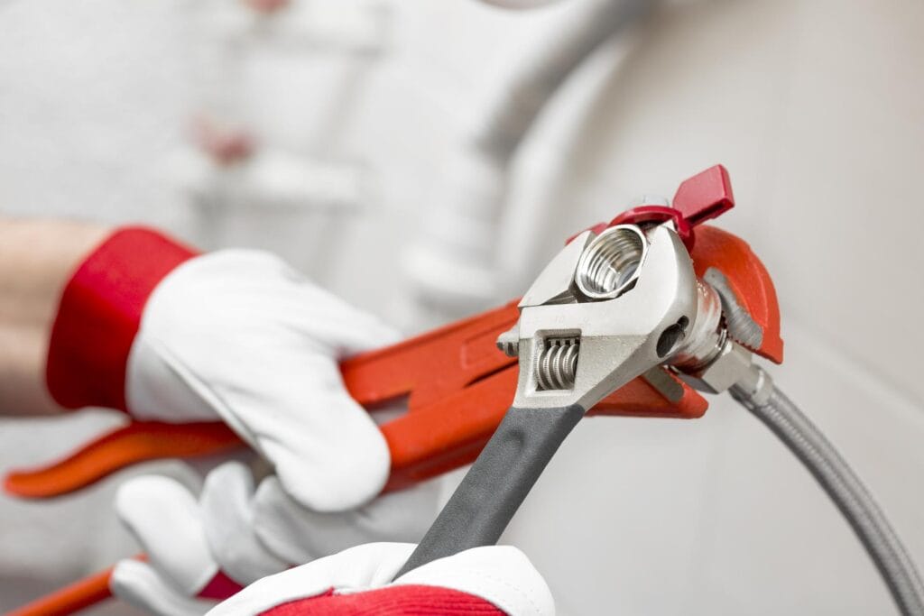 Plumber holding pipe wrenches for an emergency repair in Warminster