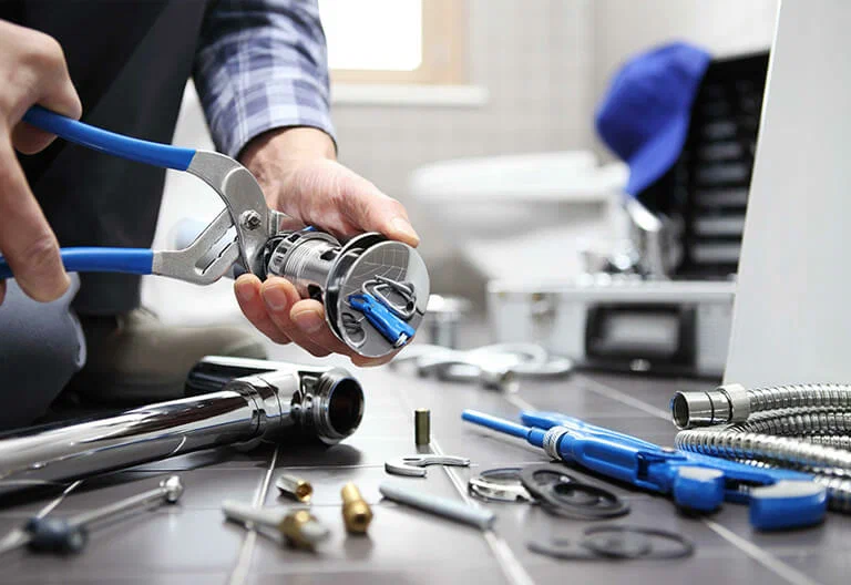 Technician repairing a plumbing fixture with professional tools in Warminster
