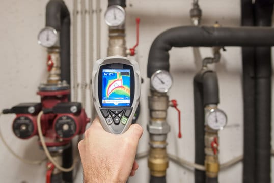 Plumber using a thermal imaging camera to inspect pipes in Warminster