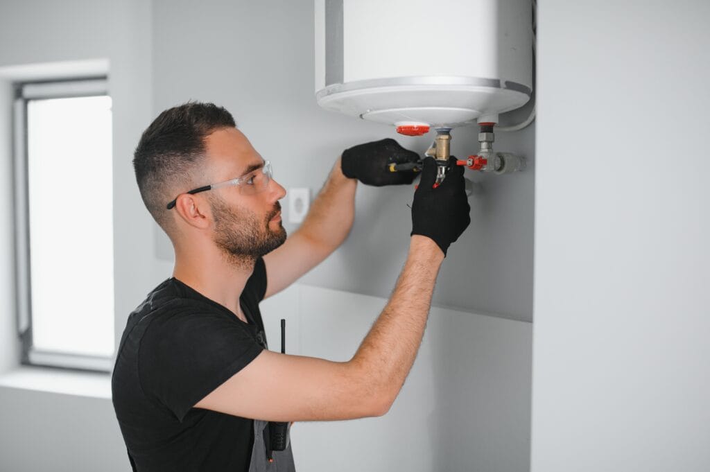 Technician performing water heater maintenance in Warminster