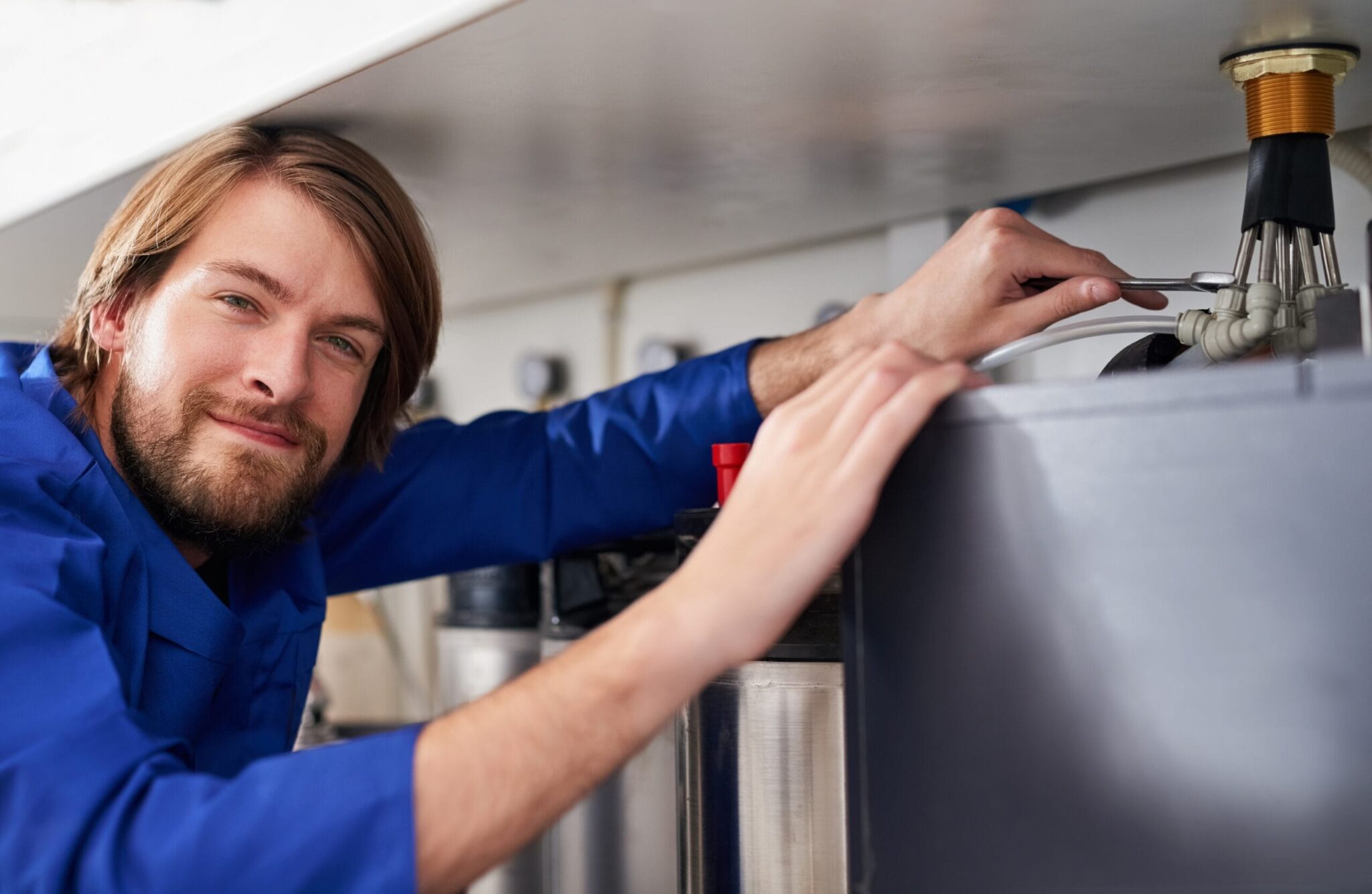 Technician servicing a residential water heater tank in Warminster